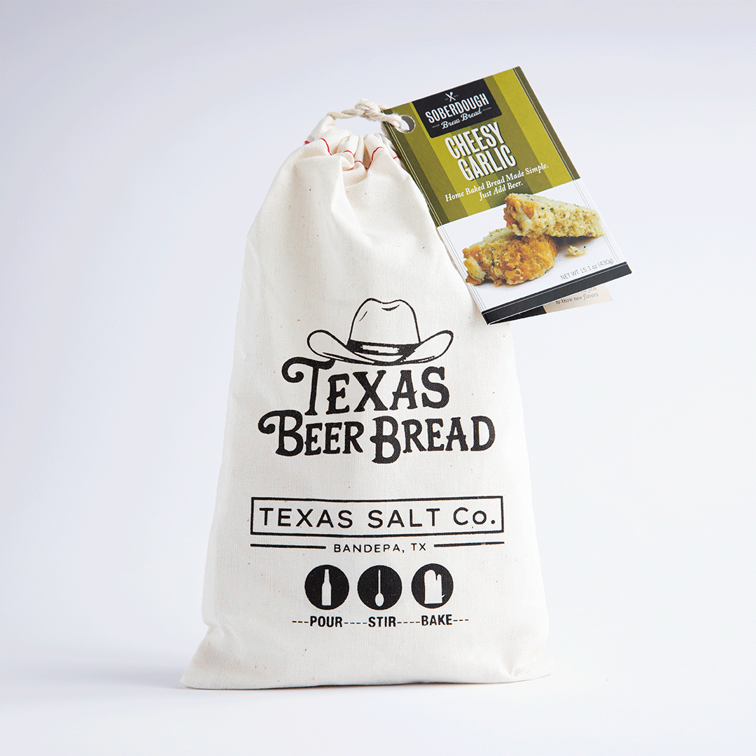 Texas Beer Bread mix in a drawstring bag, labeled Cheesy Garlic flavor, with SoberDough tag attached
