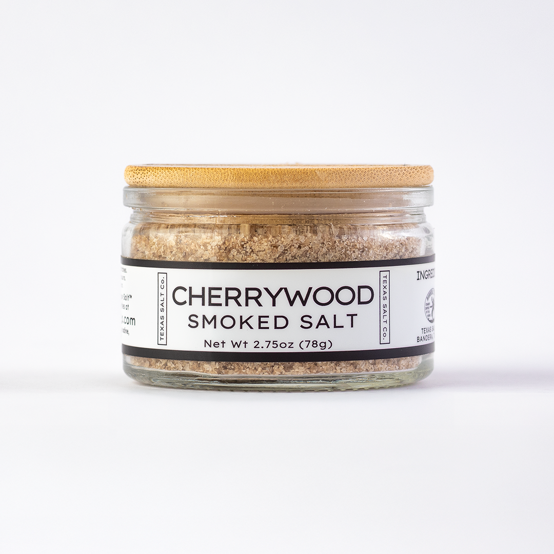 Texas Salt Co. Cherrywood Smoked Salt 2.75oz bamboo-lid jar with visible smoked salt texture inside, photographed on a white background.