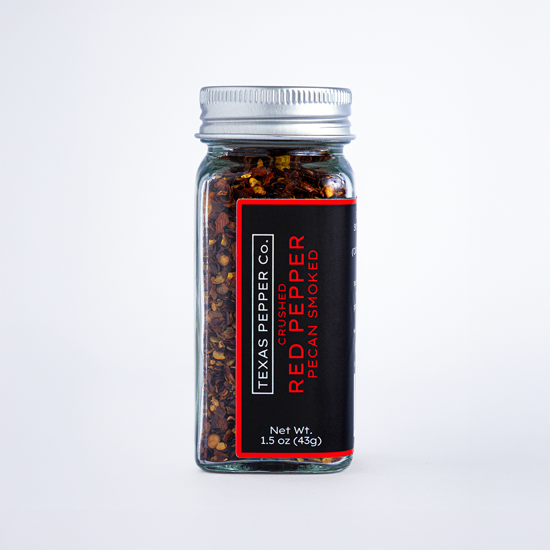 Texas Pepper Co. Crushed Red Pepper Pecan Smoked – Front view of 1.5 oz glass spice jar with silver lid and black label