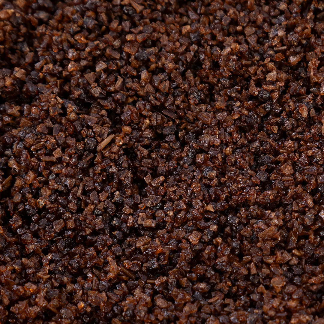 Close-up of Texas Salt Co. Espresso Finishing Salt showing coarse, dark coffee-infused salt granules.