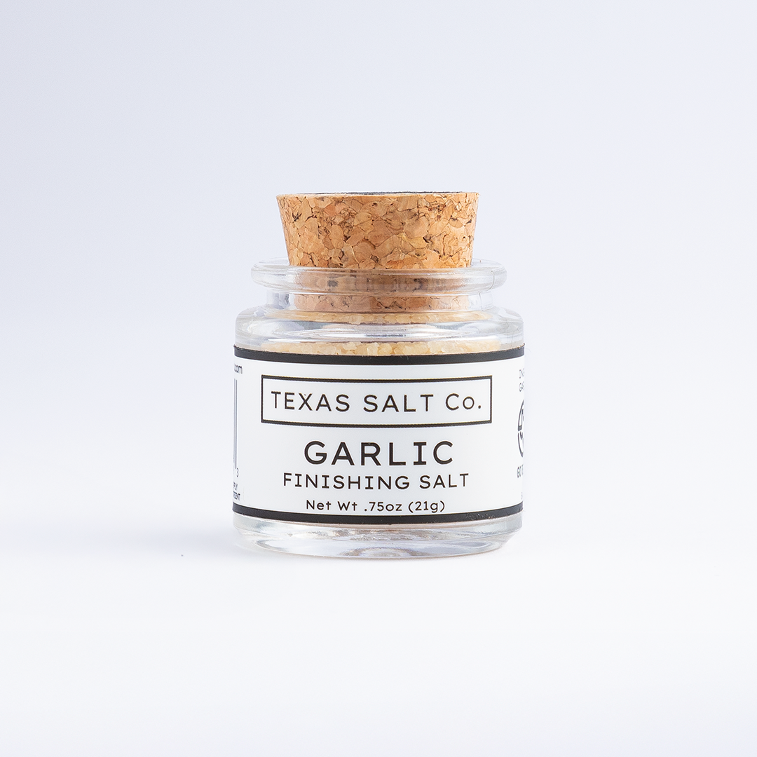 Small jar of Texas Salt Co. Garlic Finishing Salt with cork lid, 0.75 oz size, on a white background.