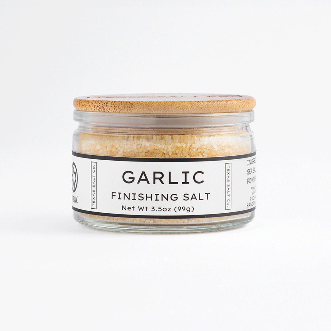 3.5 oz jar of Texas Salt Co. Garlic Finishing Salt with bamboo lid, shown on a white background.