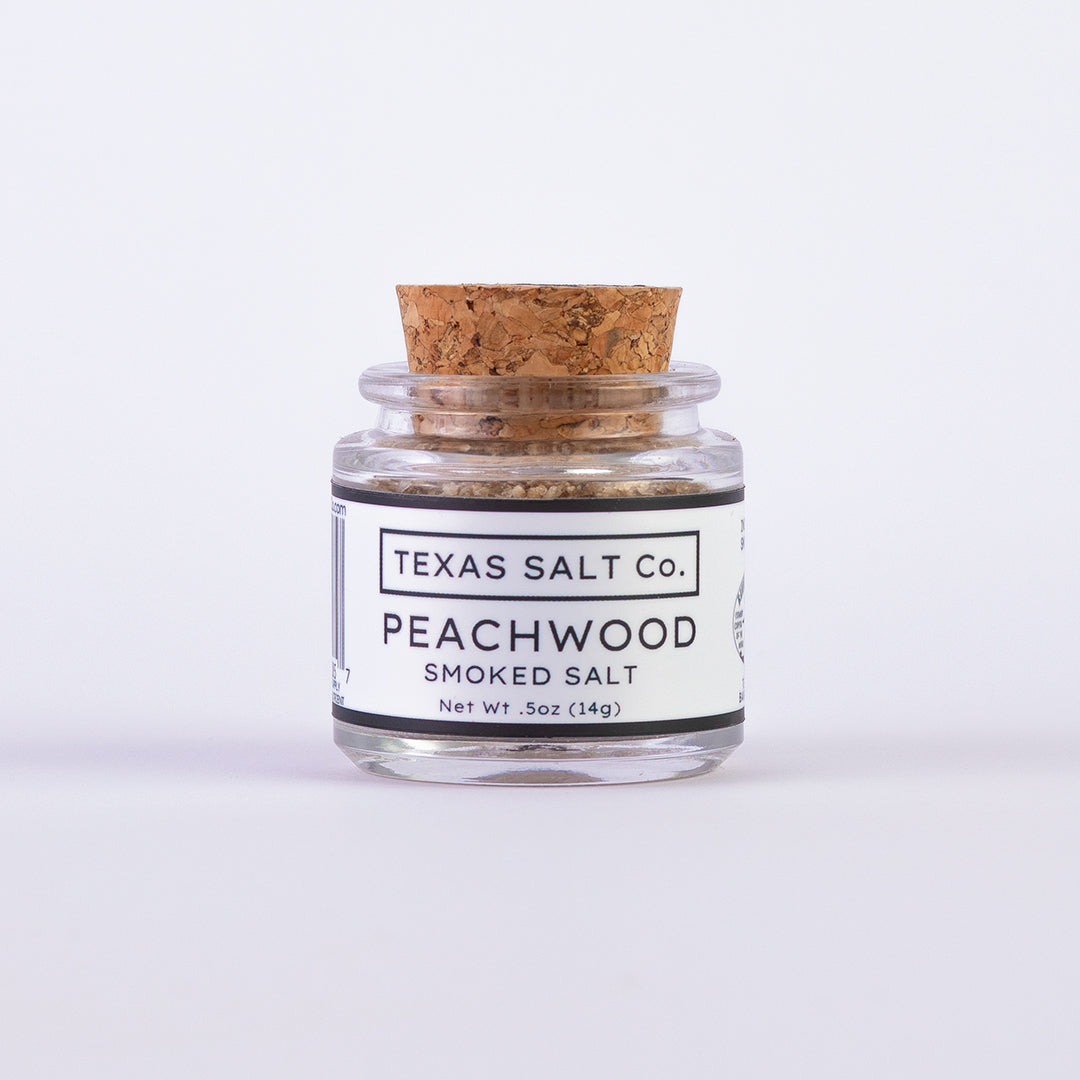 Mini glass jar of Texas Salt Co. Peachwood Smoked Salt, 0.5 oz (14g), with cork lid and white label.