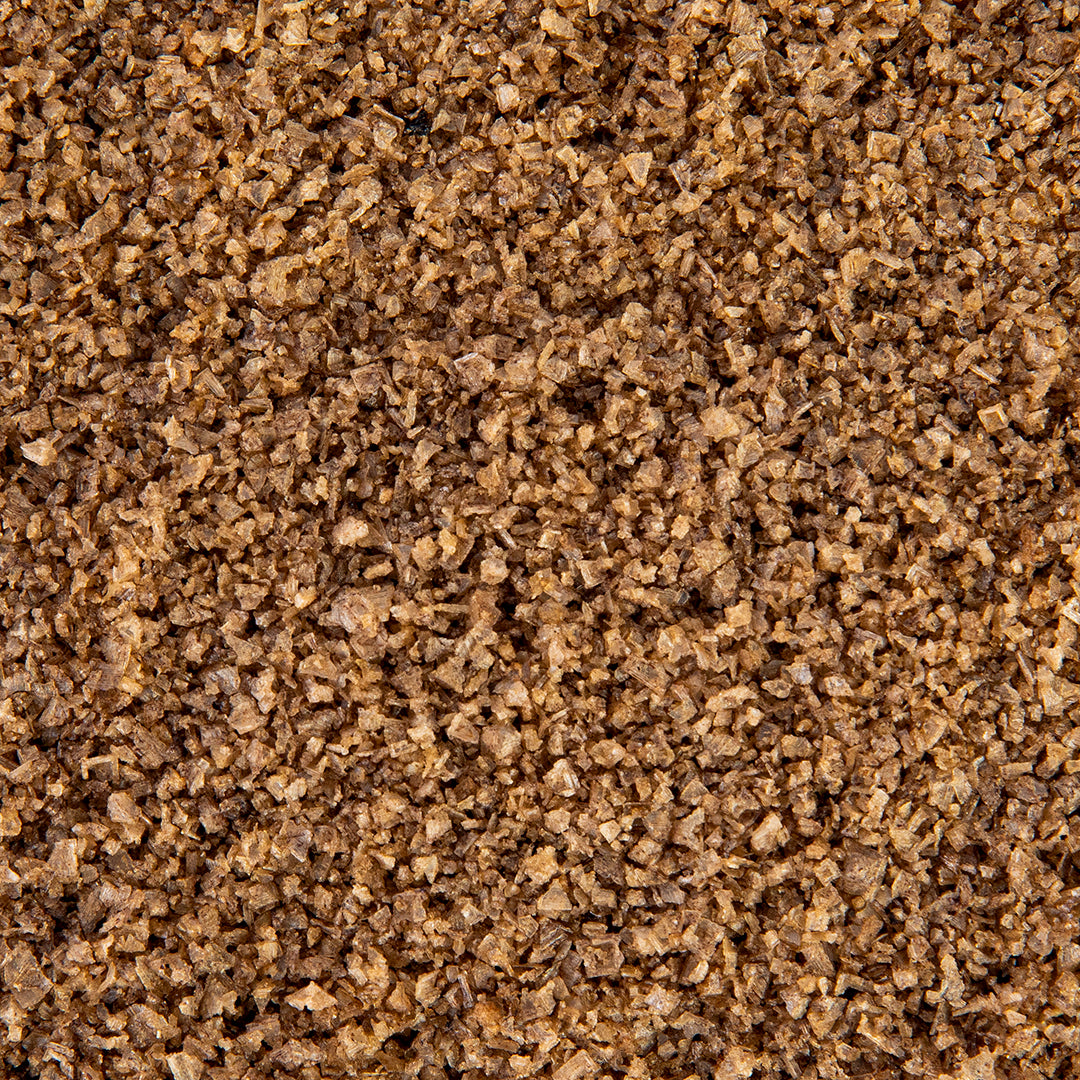 Macro close-up of Texas Salt Co. Peachwood Smoked Salt showing smoky flake texture.