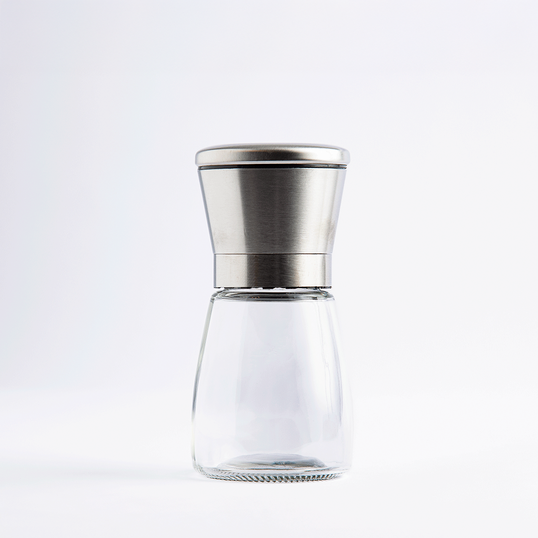 Short glass salt and pepper mill with stainless steel top, empty, on white background