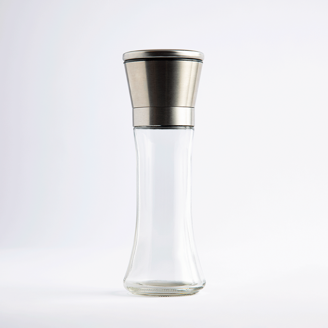 Tall glass salt and pepper mill with stainless steel top, empty, on white background