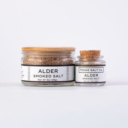 Texas Salt Co. Alder Smoked Salt in 3oz bamboo-lid jar and .5oz cork-top jar displayed side by side on a white background.