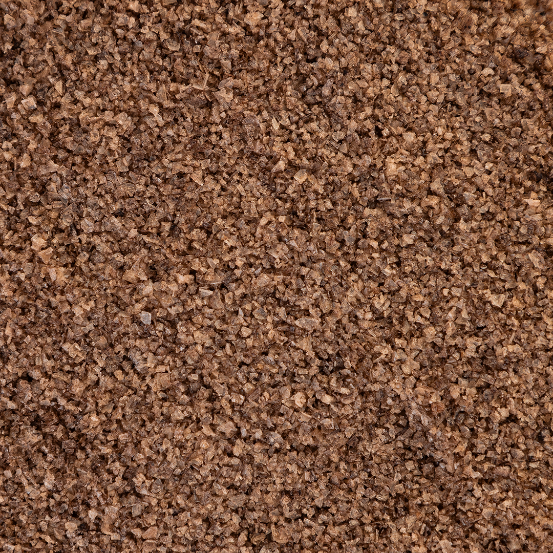 Close-up texture shot of Texas Salt Co. Charcoal Smoked Salt showing coarse grains and natural charcoal-smoke color.