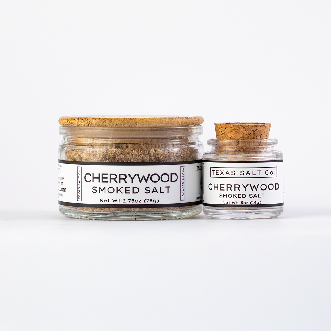 Texas Salt Co. Cherrywood Smoked Salt in 2.75oz bamboo-lid jar and .5oz cork-top jar displayed side by side on a white background.