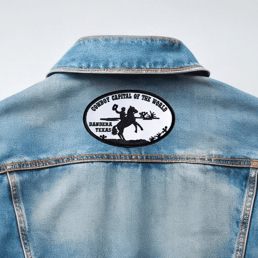 Back of denim jacket featuring black and white embroidered patch reading "Cowboy Capital of the World, Bandera Texas" with cowboy silhouette