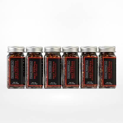 Six jars set of Texas Pepper Co. Red Pepper featuring Applewood, Oak, Pecan, Mesquite, Bourbon Barrel, and Hickory on a white background.