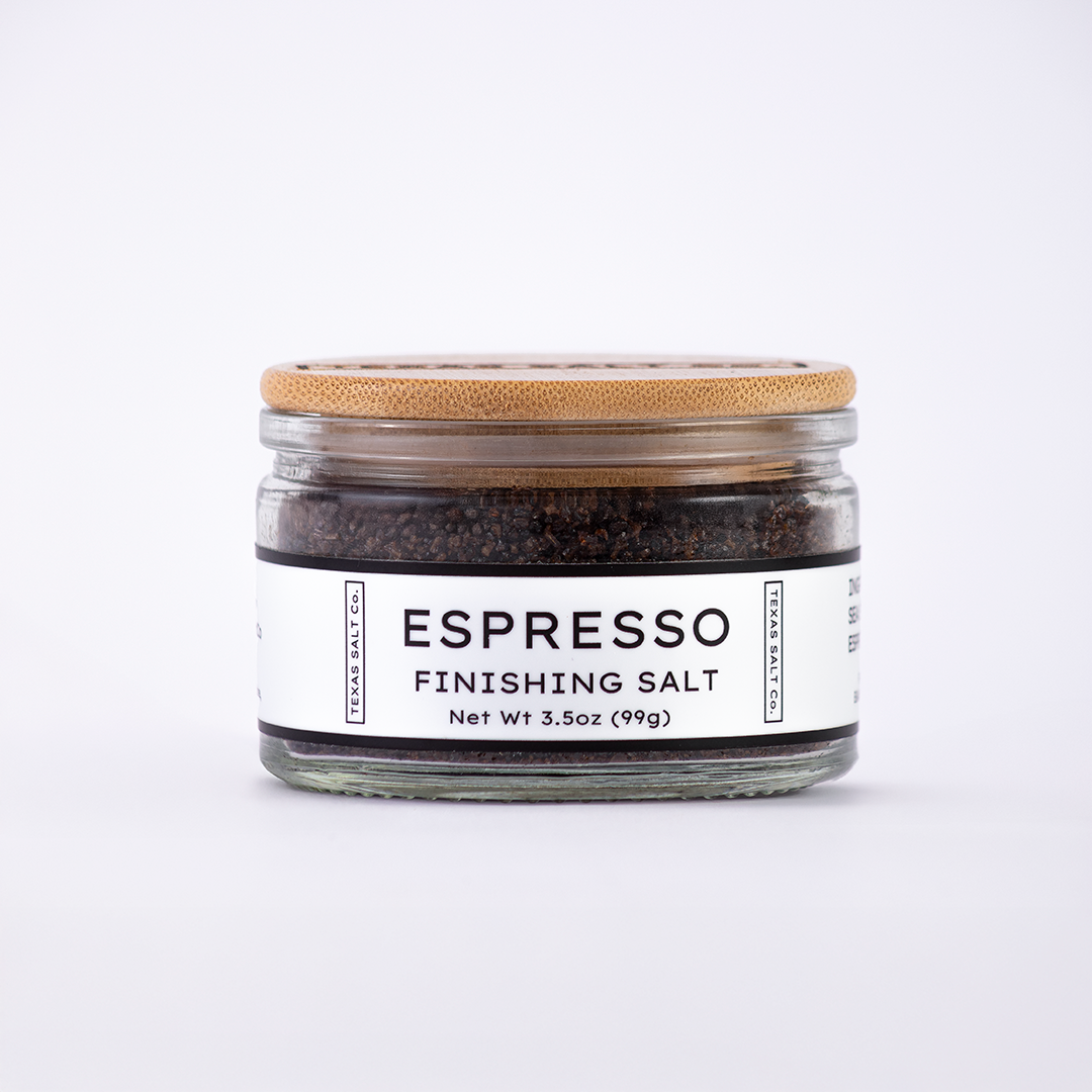 Glass jar of Texas Salt Co. Espresso Finishing Salt, 3.5 oz (99g), with bamboo lid and white label, filled with dark espresso salt.