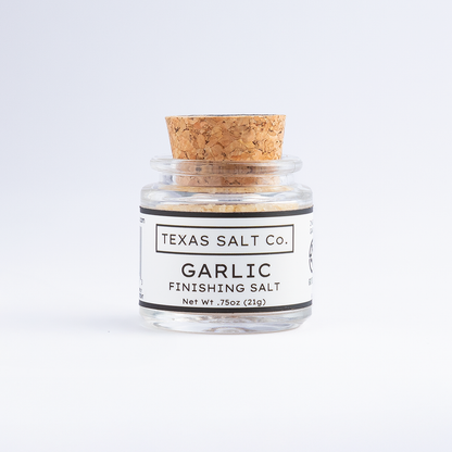 Small jar of Texas Salt Co. Garlic Finishing Salt with cork lid, 0.75 oz size, on a white background.