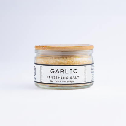 3.5 oz jar of Texas Salt Co. Garlic Finishing Salt with bamboo lid, shown on a white background.