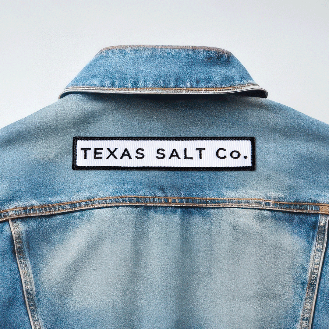 Texas Salt Co. embroidered iron-on patch applied to the back of a light blue denim jacket