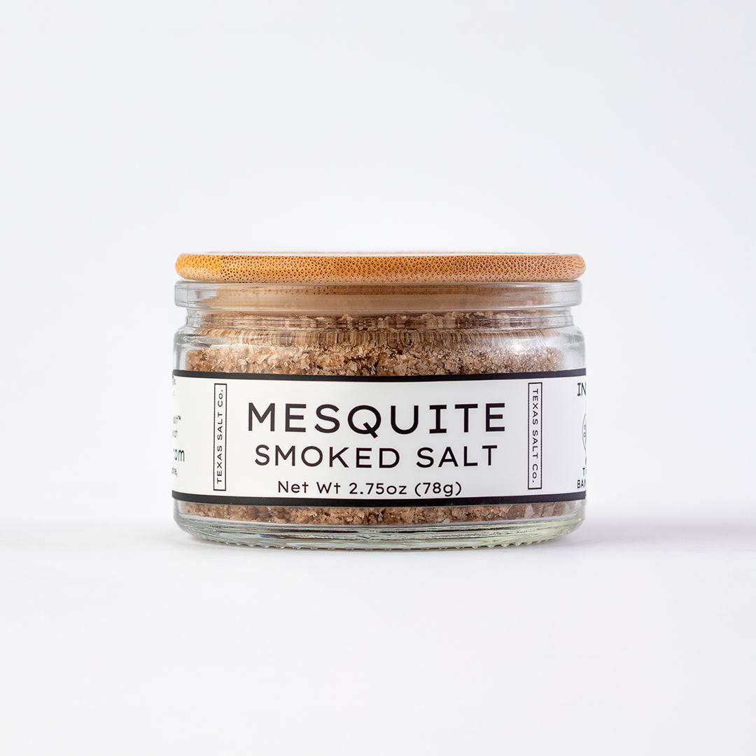 Texas Salt Co. Mesquite Smoked Salt 2.75oz bamboo-lid jar with visible smoked salt texture inside, photographed on a white background.