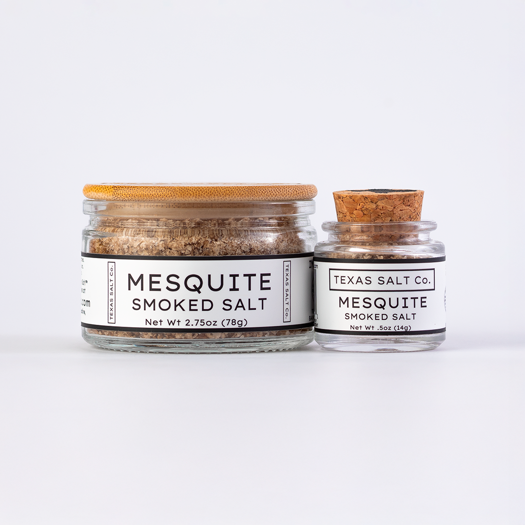 Texas Salt Co. Mesquite Smoked Salt in 2.75oz bamboo-lid jar and .5oz cork-top jar displayed side by side on a white background.