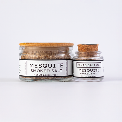 Texas Salt Co. Mesquite Smoked Salt in 2.75oz bamboo-lid jar and .5oz cork-top jar displayed side by side on a white background.
