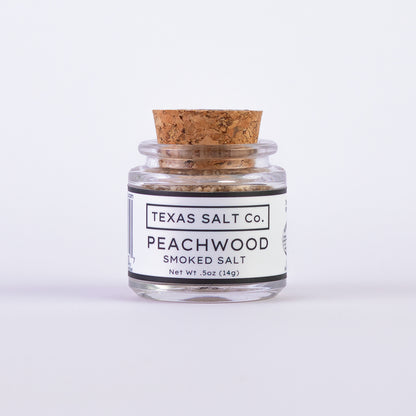 Mini glass jar of Texas Salt Co. Peachwood Smoked Salt, 0.5 oz (14g), with cork lid and white label.