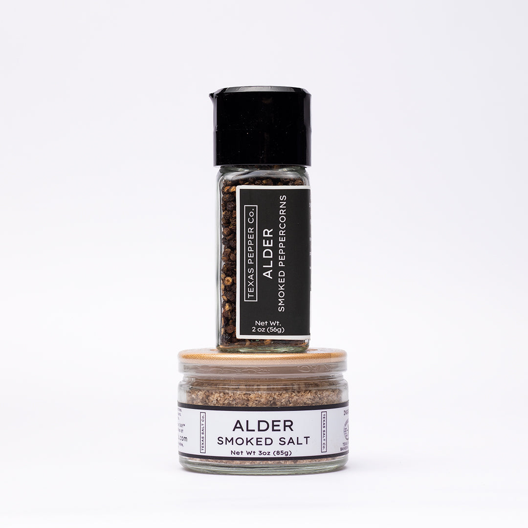 Set of two jars including a grinder-top Alder Smoked Peppercorn and a flat bamboo-lid Alder Smoked Salt, both with white Texas Salt Co. labels