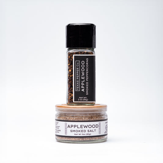 Applewood Smoked Peppercorn with grinder lid paired with flat-lid Applewood Smoked Salt jar, both labeled with Texas Salt Co. branding