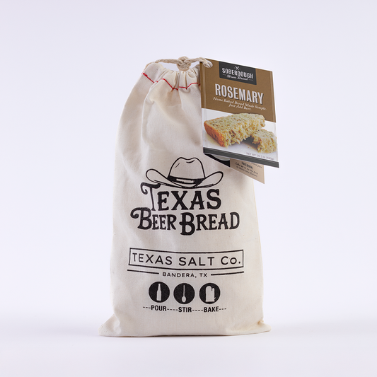 Texas Salt Co. Texas Beer Bread mix in a cloth bag with a Rosemary Bread flavor tag attached, labeled with “Pour, Stir, Bake” instructions.
