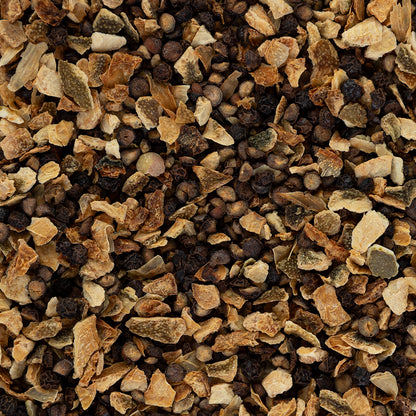 Close-up of a pile of crushed dried lime rinds and half cracked peppercorn.